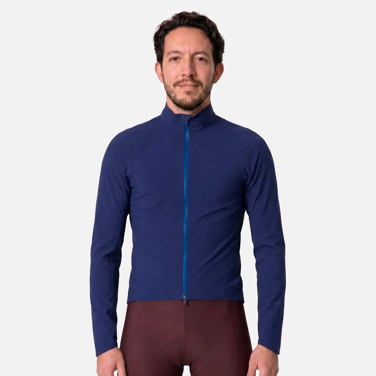 Man wearing navy blue cycling jacket with blue zipper and brown cycling shorts