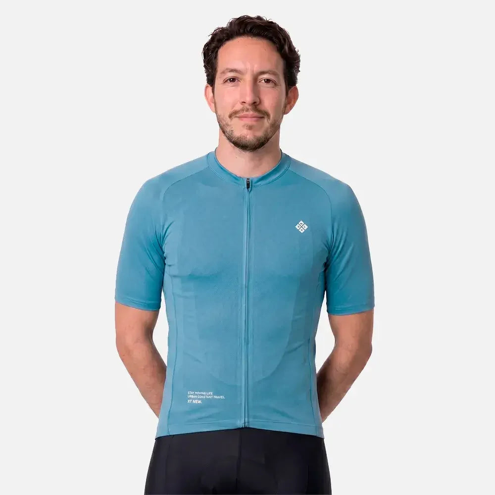 Man wearing teal cycling jersey with zipper and logo, paired with black shorts
