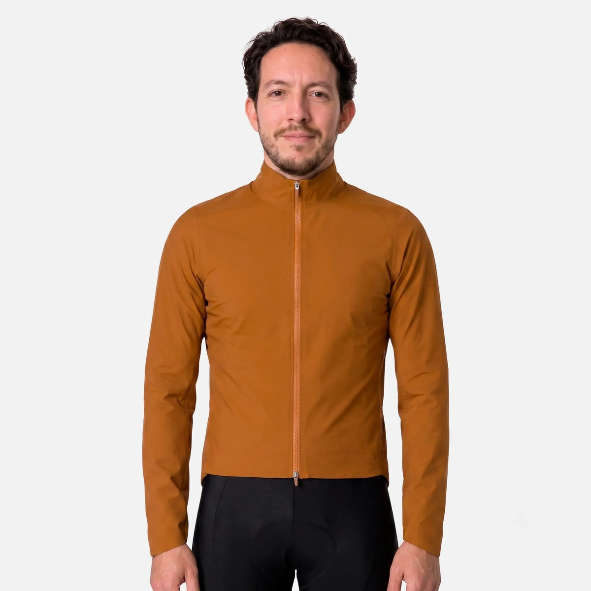 Man wearing mustard brown cycling jacket with full zip and black bib shorts