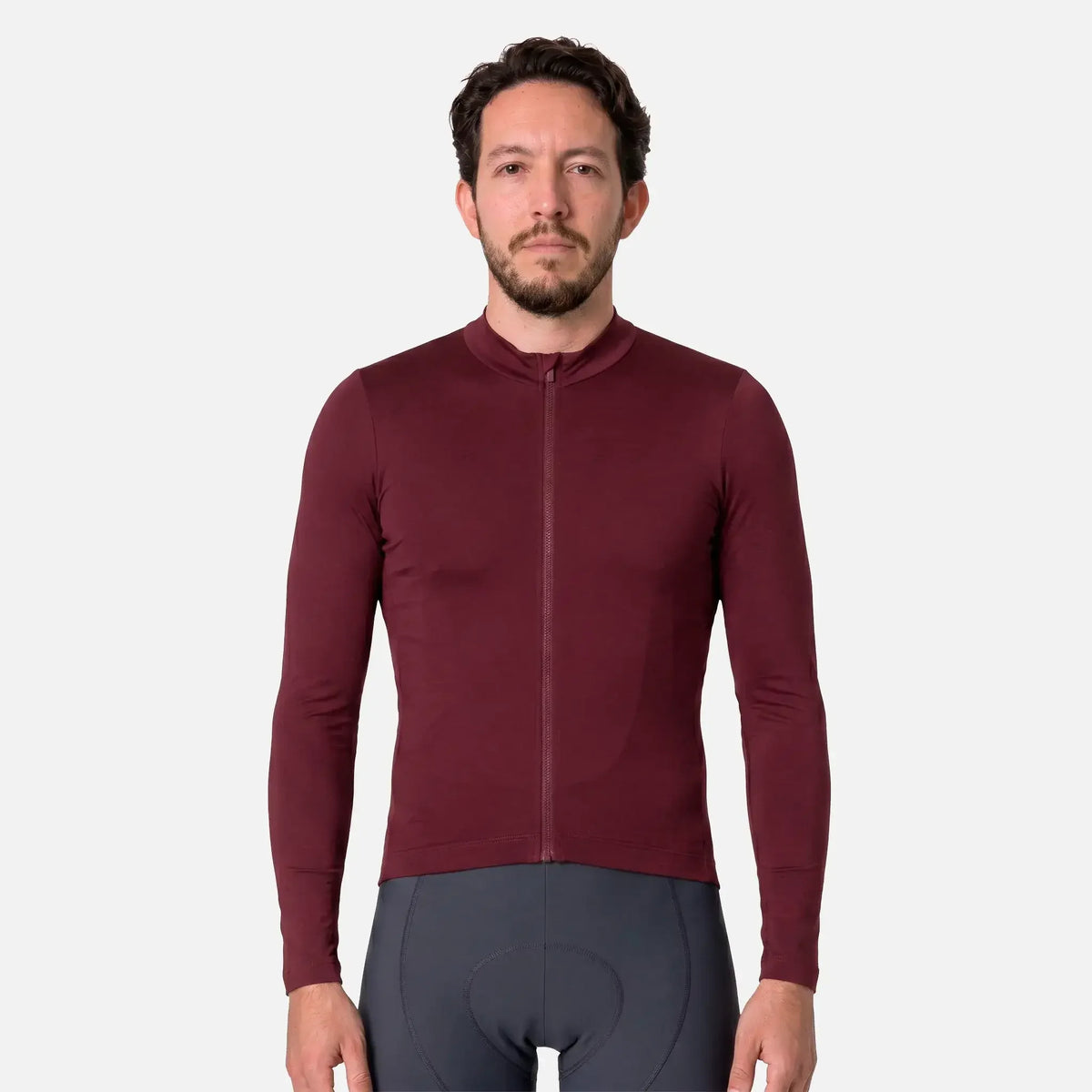 Man wearing maroon long-sleeve cycling jersey with full zipper and gray padded shorts