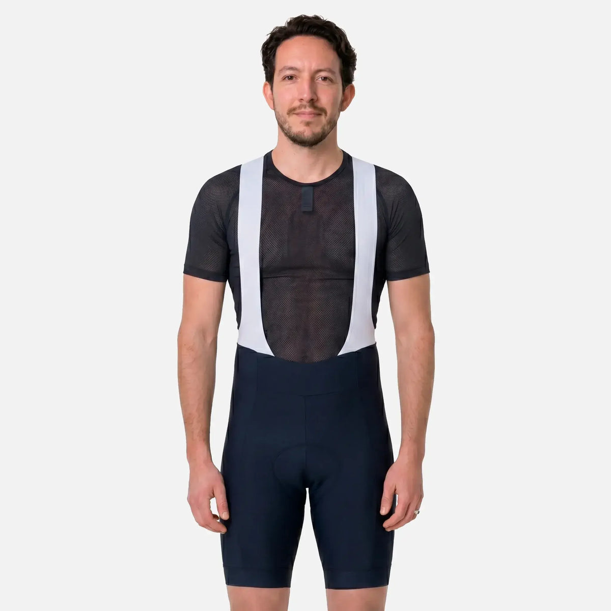 Man wearing black cycling bib shorts with white straps and mesh jersey