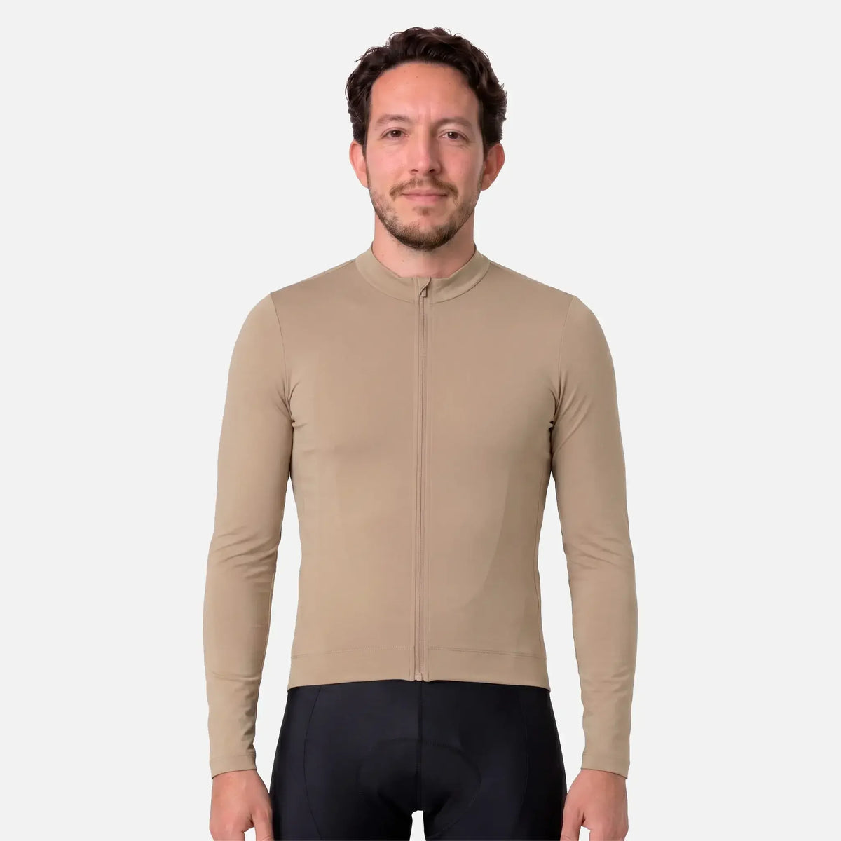 Man wearing beige long-sleeve cycling jersey with full zipper and black padded shorts